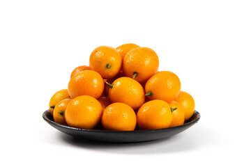 ripe cumquat or kumquat fruit in plate isolated on white background