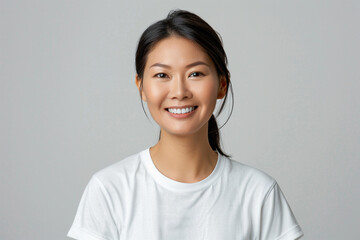짧은 머리에 흰 티셔츠를 입고 미소 짓는 50대 한국인 여성 - obrazy, fototapety, plakaty