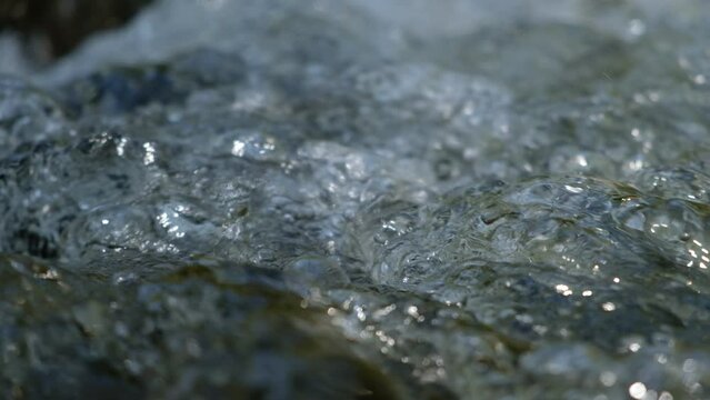 Macro and Closeup.The water flows in the stream that many air bubbles form.