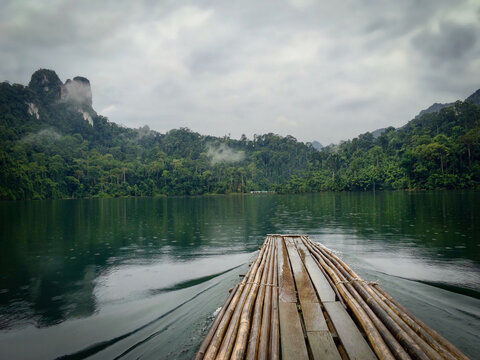 Bamboo raft on misty rainforest lake &mdash; peaceful jungle adventure