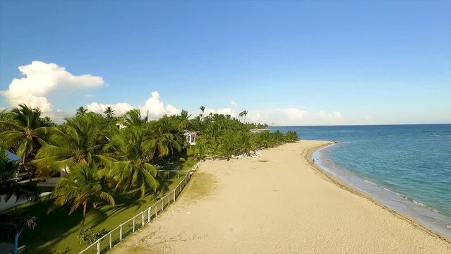 Approaching drone shot slightly moving to the right to show the fenced houses in Miami Beach, facing the crystal clear blue waters of the Mediterranean Sea, located in the islands of Greece.