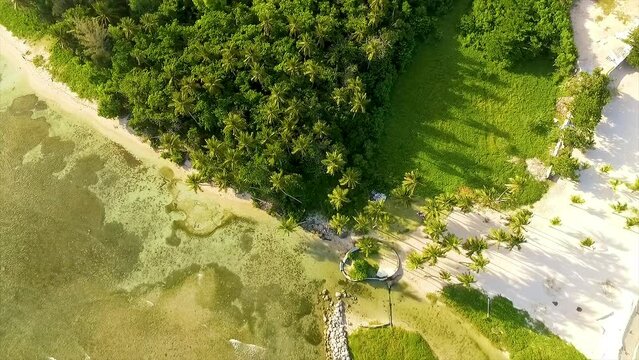 Drone panning overhead, moving from the Miami beachfront to reveal the surging waves of the Mediterranean Sea to the coast of Itea in Greece.