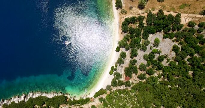 Overhead orbiting drone shot of Foki Beach, a secluded public resort near the village of Fiskardo, located in the island of Kefalonia, Greece.