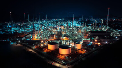 Oil refinery plant industry factory zone, oil and gas petrochemical industrial, oil storage tank and pipeline steel at night scene shot blue sky backgrounds,