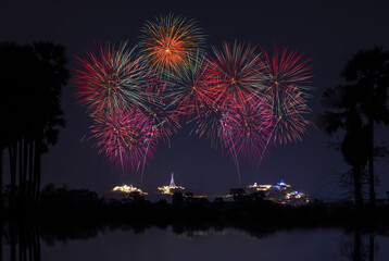Firework over the mountain in the festival (Phra Nakhon Khiri) and shadow of the sugar palm tree reflection in water front process.