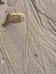 Rivulets of running water on a sandy beach form abstract patterns looking like aerial photographs...