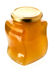Glass bottle of fine honey with golden lid on white background. Agriculture organic product famous for its sweet taste and health benefits and value.