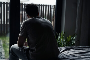 Back view of depressed man at home