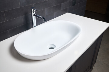 Interior of bathroom with washbasin and faucet. Bathroom interior sink with white stoneware countertop modern flat minimalistic design.