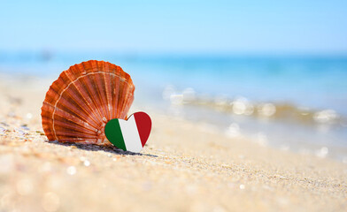 Sandy beach in Italy. Italy flag in the shape of a heart and a large shell. A wonderful seaside...
