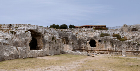 Rupestrian settlements (caves) in the Neapolis Archaeological Park in Syracuse, Sicily Italy - obrazy, fototapety, plakaty