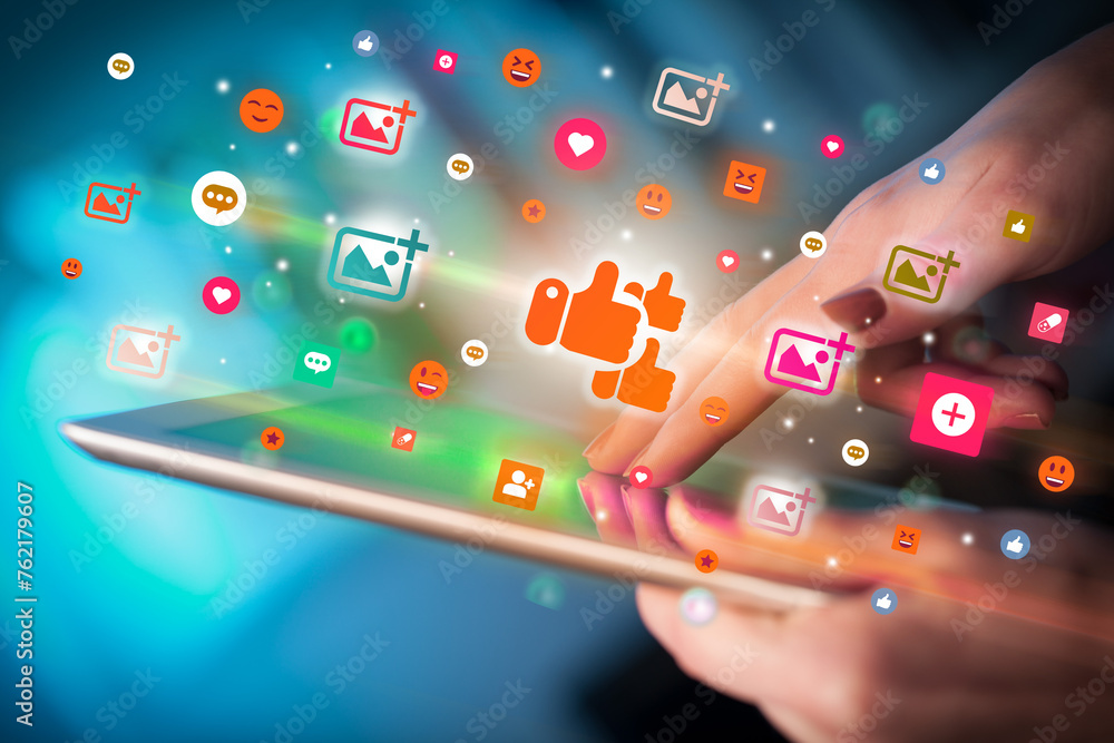 Poster close-up of a hand using tablet with social media icons
