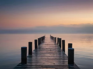 Plexiglas foto achterwand A wooden pier at misty dawn in a still sea HD Wallpapers © Abdulhaq