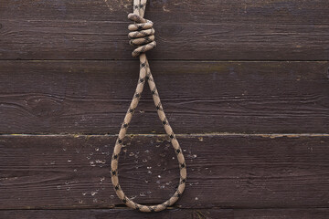 Rope with noose for suicide on wooden background