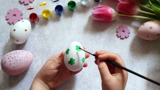 Child painting Easter egg at home