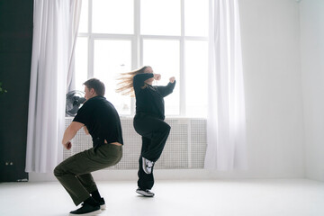 Energetic Duo Performing a Contemporary Dance Routine in a Bright White Studio