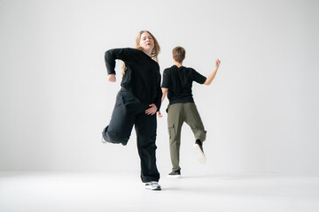 Contemporary Dance Duo Performing Routine Moves in a white Studio