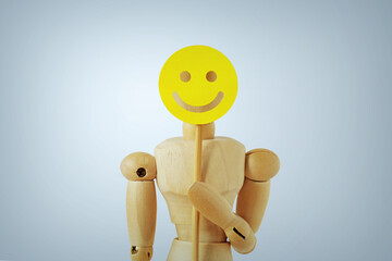 Wooden mannequin with happy face paddle - Concept of happiness, fun and positive feedback