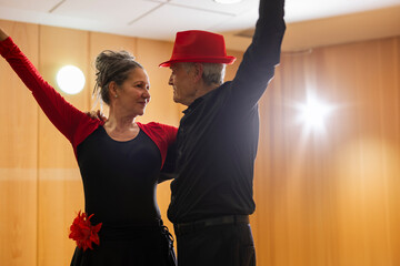 senior couple looking at each other posing for dance class in dance workshop for retirees