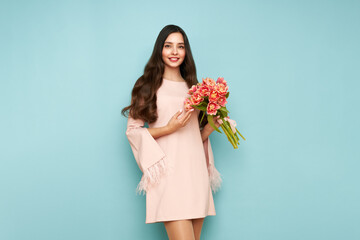 Happy beauty woman with pink tulip bouquet on light blue background. 8th of March celebration - 762201025