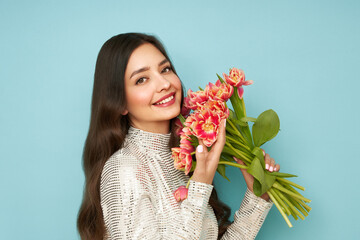 Happy beauty woman with pink tulip bouquet on blue background. 8th of March celebration - 762201046
