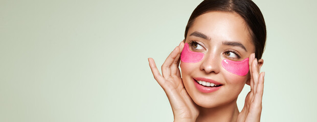 A young beautiful smiling woman with cosmetic patches on her eyes. Cosmetic procedures skin care...