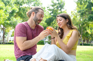 Picnic time. Happy couple relaxing on blanket enjoying picnic in sunny garden. Love and tenderness, dating, romance. Lifestyle concept.