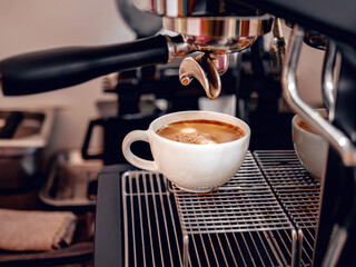 Coffee extraction from the coffee machine with a portafilter pouring coffee into a cup,Espresso poruing from coffee machine at coffee shop