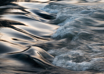 Rapid water flows in stream over stony bottom making cascades - abstract landscape close up