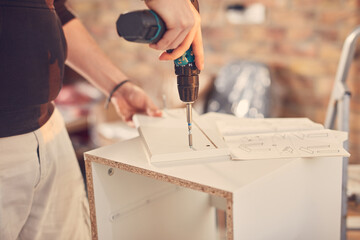 Man working and assembling furniture in a new apartment.