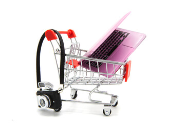 Shopping supermarket cart with camera and laptop inside isolated on a white background. Online...