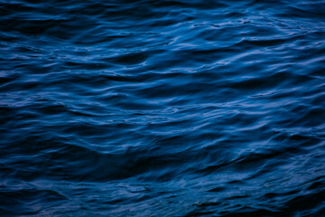 Blue ocean water with waves background. An abstract background of seawater flow under light...