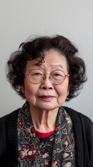 Une femme âgée de type asiatique portant des lunettes de vue au format portrait.
