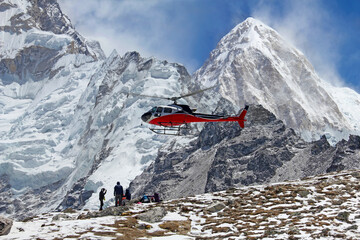 Goup of climbers in the Himalayas, view on peak Pumori. Rescue helicopter in action, Nepal
