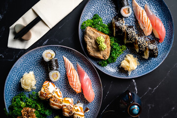 flat lay picture of luxury sushi set with nigiri, maki and rolls on a black background © Ondrej