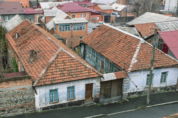 Fototapeta na wymiar Top view of old houses with tiled roofs. House territory near old houses. The old district in the city of Vladikavkaz.