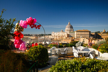 Terrace with Love balloons and tables. St Peter's Basilica on background