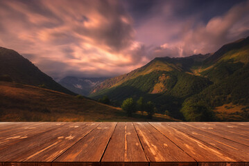 Summer beautiful background with colorful mountains and empty wooden table in nature outdoor. Natural template landscape