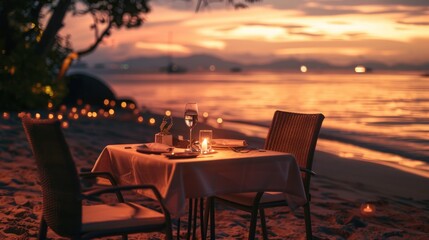 Private romantic dinner setup on the beach with sunset.
