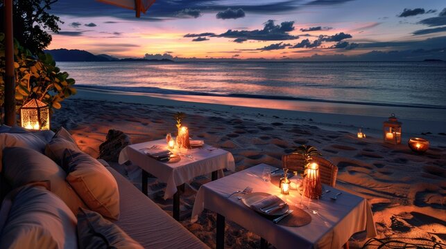 Private romantic dinner setup on the beach with sunset.
