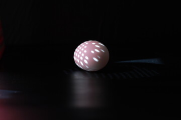 egg in the rays of light on a black background 