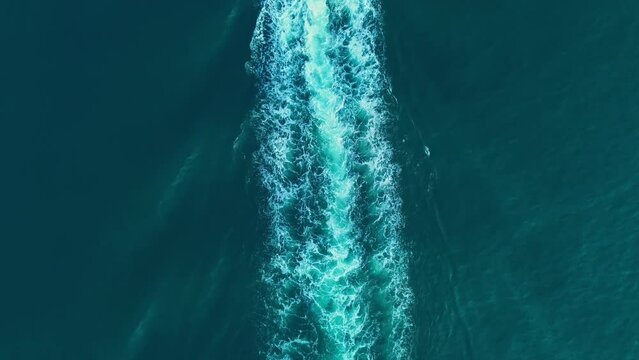 White water stains with ripples created by ship propellers on the sea.