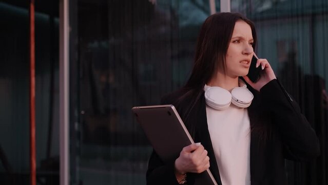 A businesswoman working with a laptop outdoors. Depicting an office worker, social media manager, or freelancer enjoying fresh air while working outside.