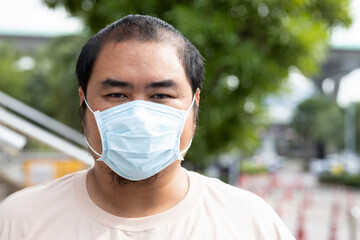 Unhappy, stressed, upset middle aged man wearing face mask for seasonal flu and dust pollution protection
