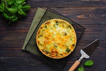 Unsweetened pastry, a whole quiche with spinach, oyster mushrooms, egg filling and cheese on a...