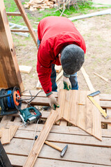 Worker sawing boards for construction - 762247493