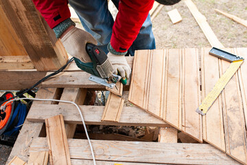 Worker sawing boards for construction - 762248295