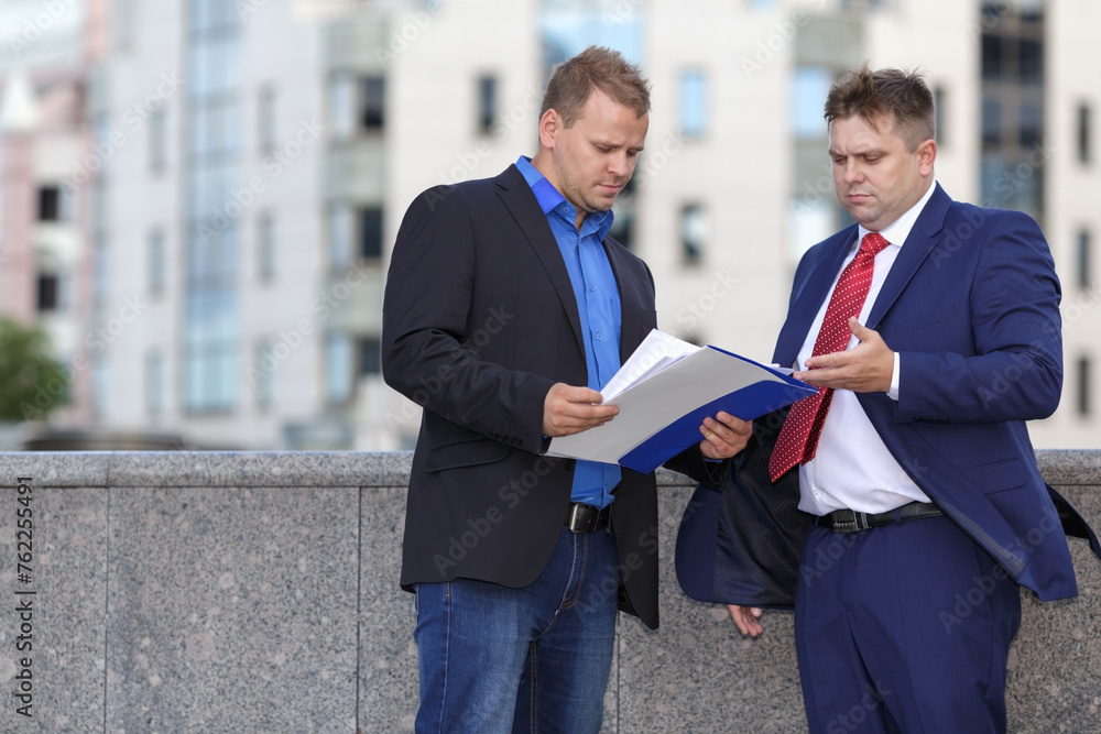 Wall mural two mature well dressed businessman outside discussing contract