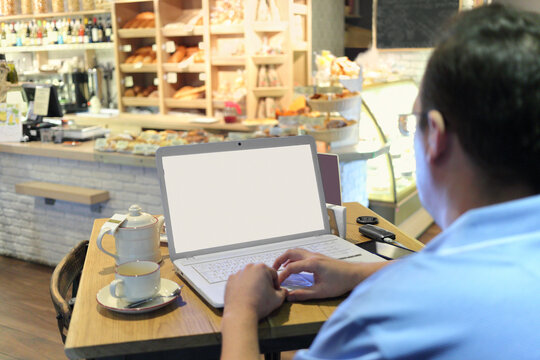 man spectacled working on his computer at cafe, focus on face