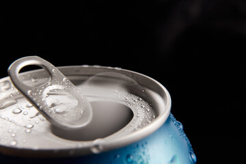 Close-up photo of aluminum open jar of beer, coke, soda with condensation water drops against black...